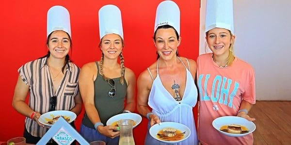 A group of people standing around plates with food.