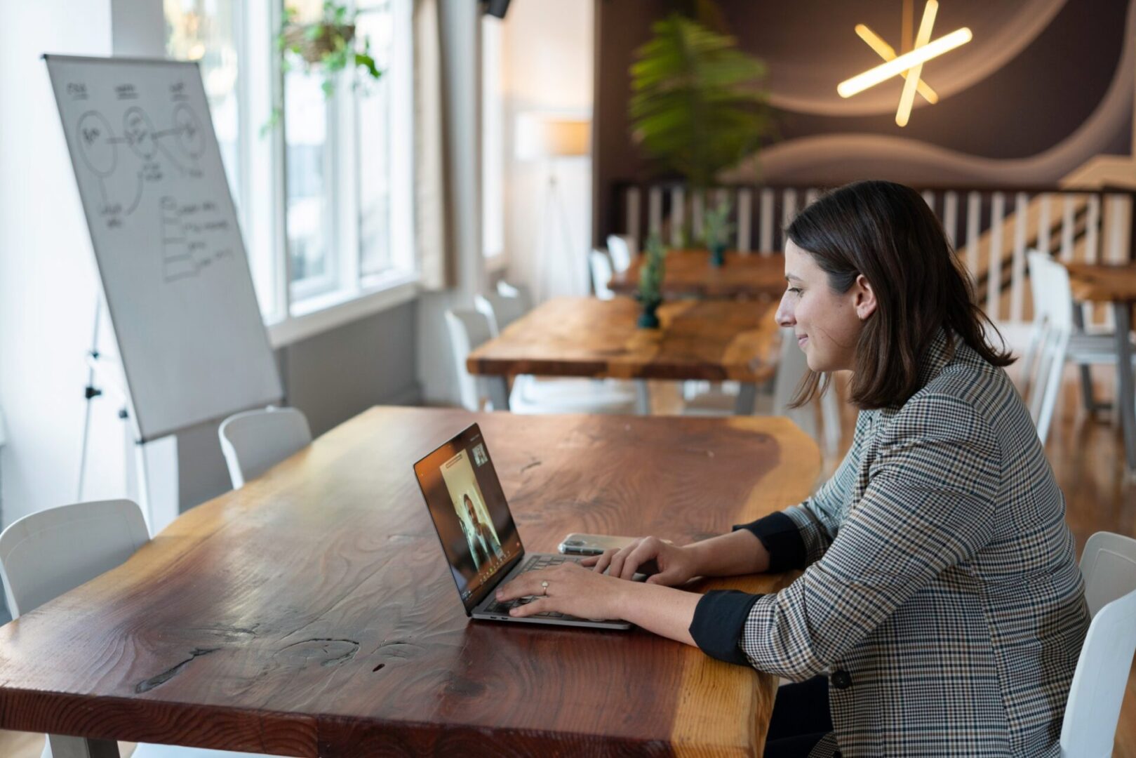 A woman sitting at a table with her laptop.