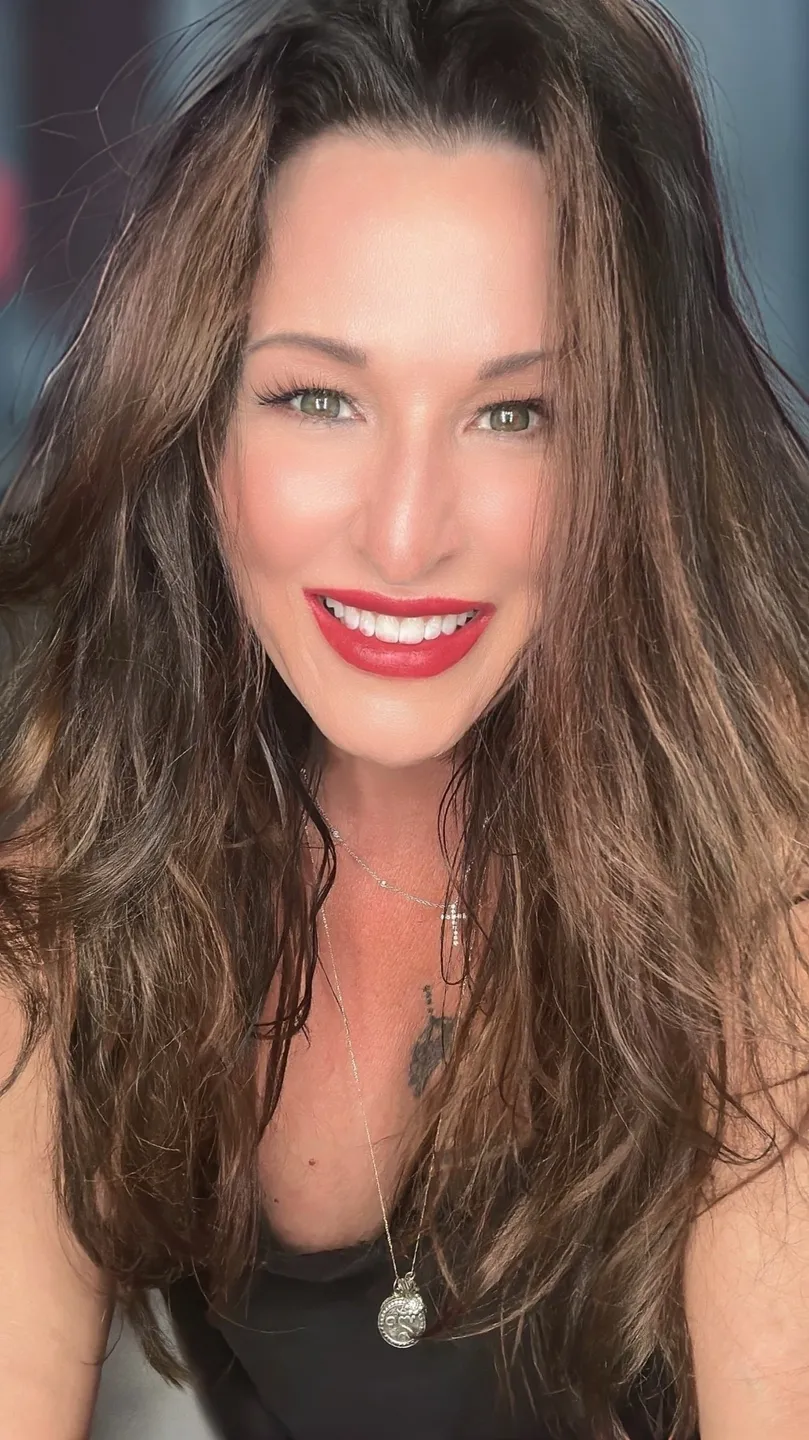 A woman with long hair and red lipstick.