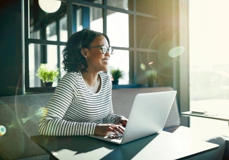 A woman sitting at a table with a laptop.