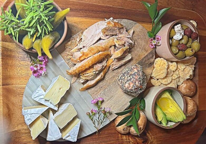 A wooden table topped with cheese and crackers.