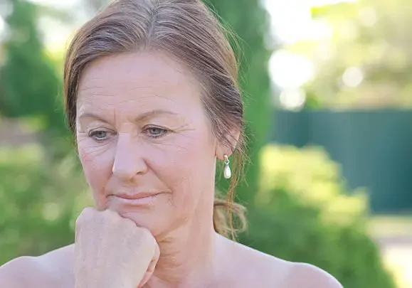 Thoughtful middle-aged woman outdoors